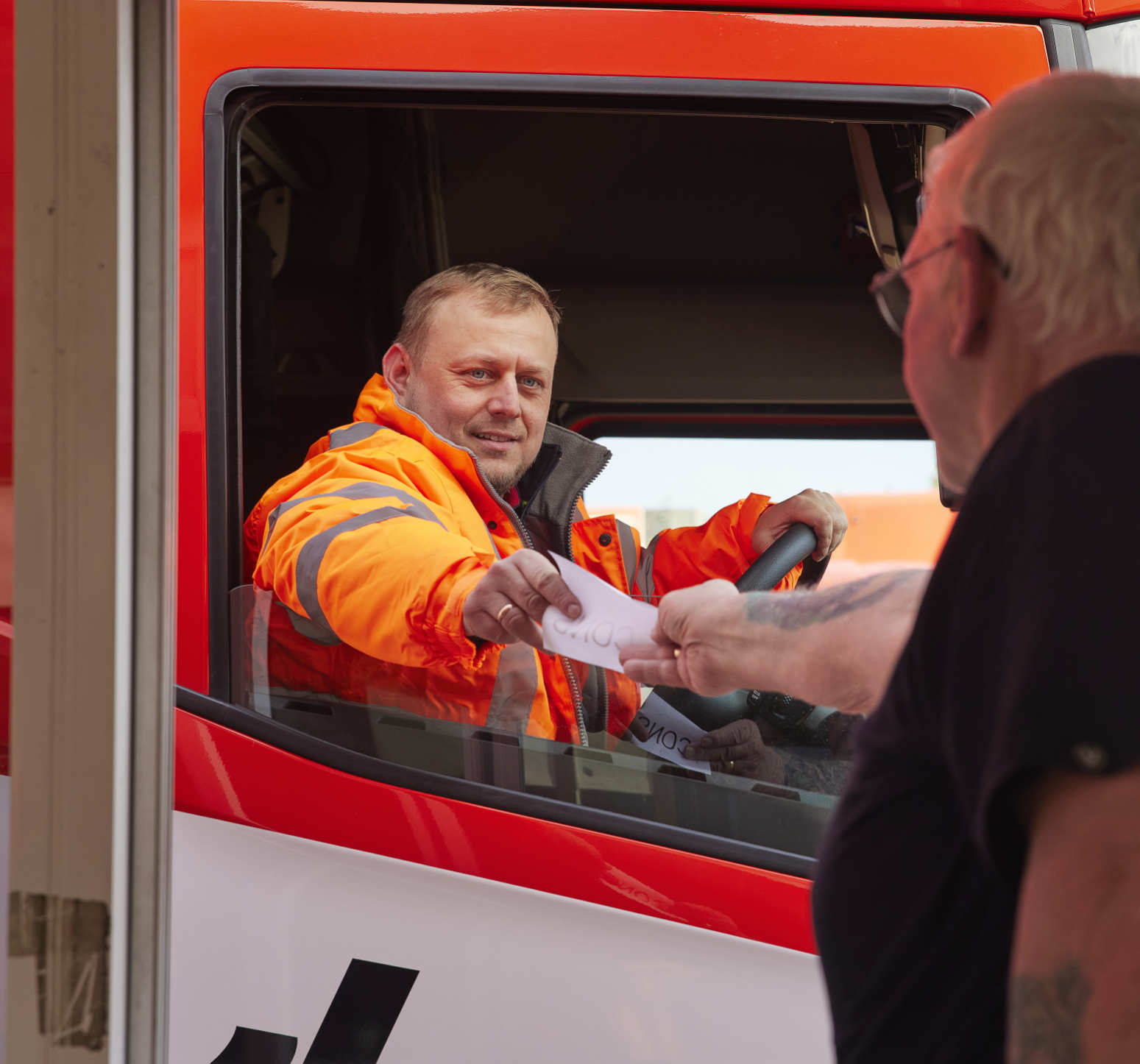 Knowles lorry driver being passed paper through window