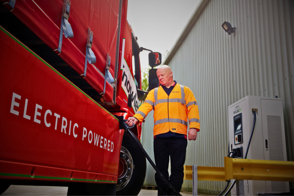 Man in hi-vis charging the Knowles electric transport lorry